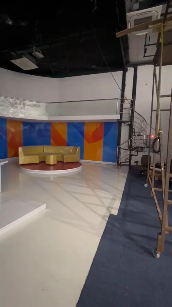 Lounge seating set, V-shaped anchor desk and glossy studio floor.