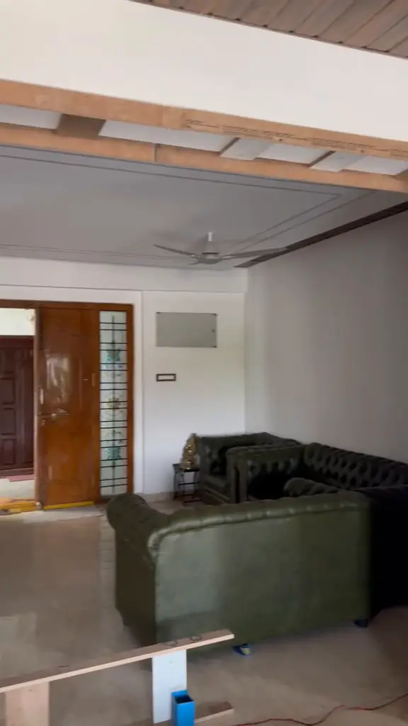 Carpenters installing wooden ceiling beams in a living room